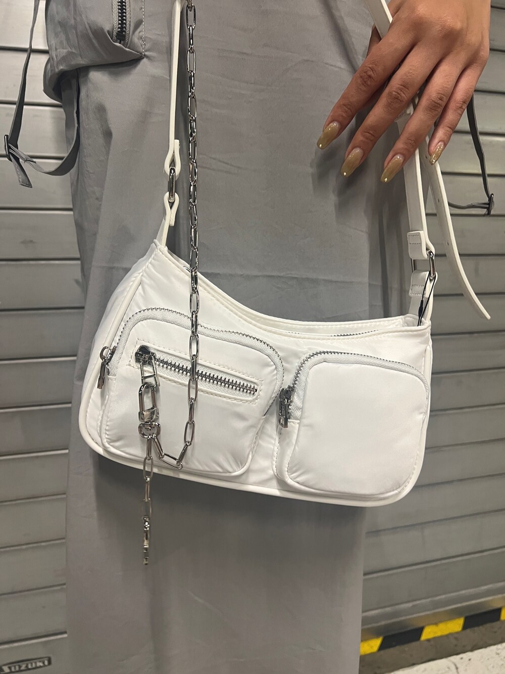 グレー系のワンピース、ホワイト系のハンドバッグ、ブラック系のサンダルを着用したレディースの夏コーディネートの5枚目の写真