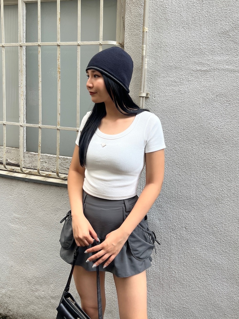 ホワイト系のTシャツ/カットソー、グレー系のスカート、ブラック系のサンダルを着用したレディースの夏コーディネートの4枚目の写真