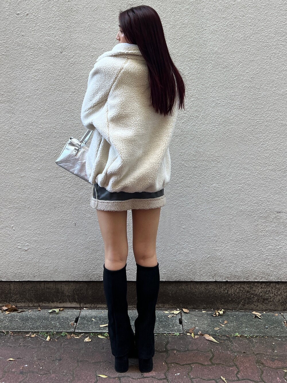 ホワイト系のTシャツ/カットソー、グレー系のスカート、ブラック系のブーツを着用したレディースの秋コーディネートの3枚目の写真