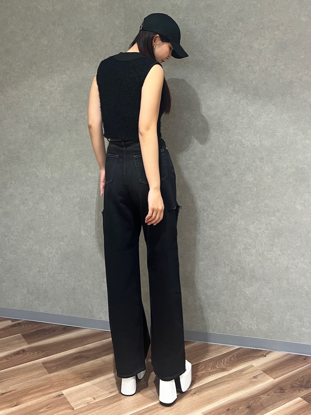 ブラック系のタンクトップ、ブラック系のデニムパンツ、ホワイト系のサンダルを着用したレディースの夏コーディネートの4枚目の写真