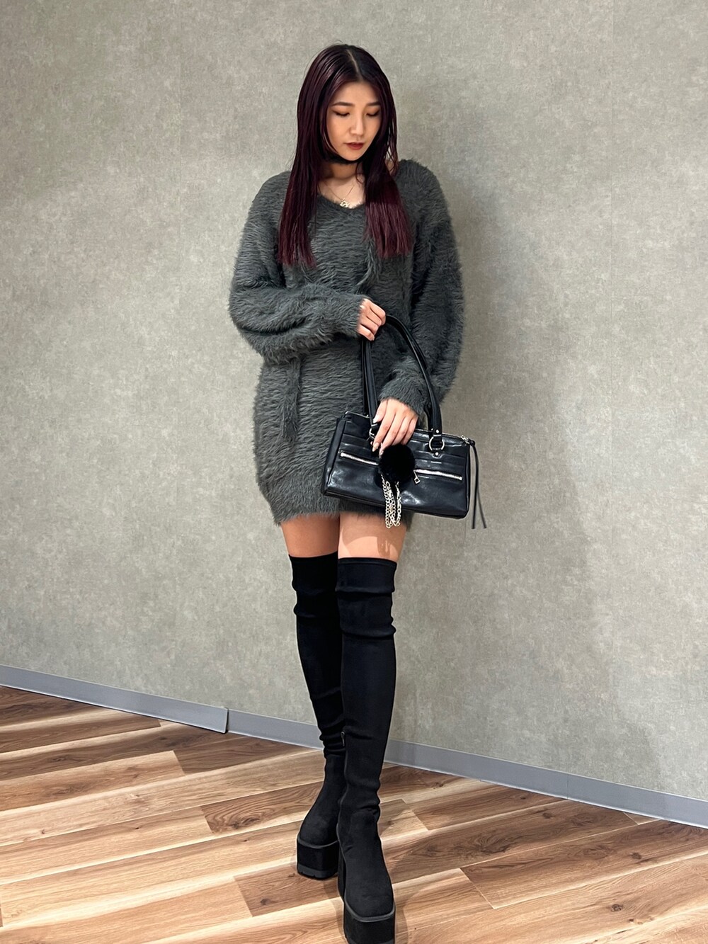 グレー系のワンピース、ブラック系のショルダーバッグ、ブラック系のブーツを着用したレディースの秋コーディネートの3枚目の写真