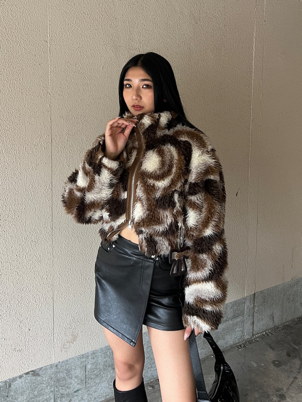 ブラウン系のブルゾン、ブラック系のスカート、ブラック系のブーツを着用したレディースの冬コーディネートの4枚目の写真