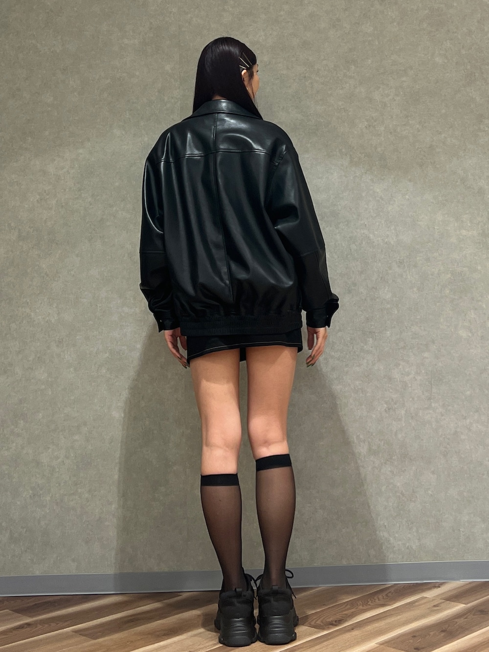 ブラック系のブルゾン、グレー系のニット/セーター、ブラック系のスカートを着用したレディースの冬コーディネートの3枚目の写真