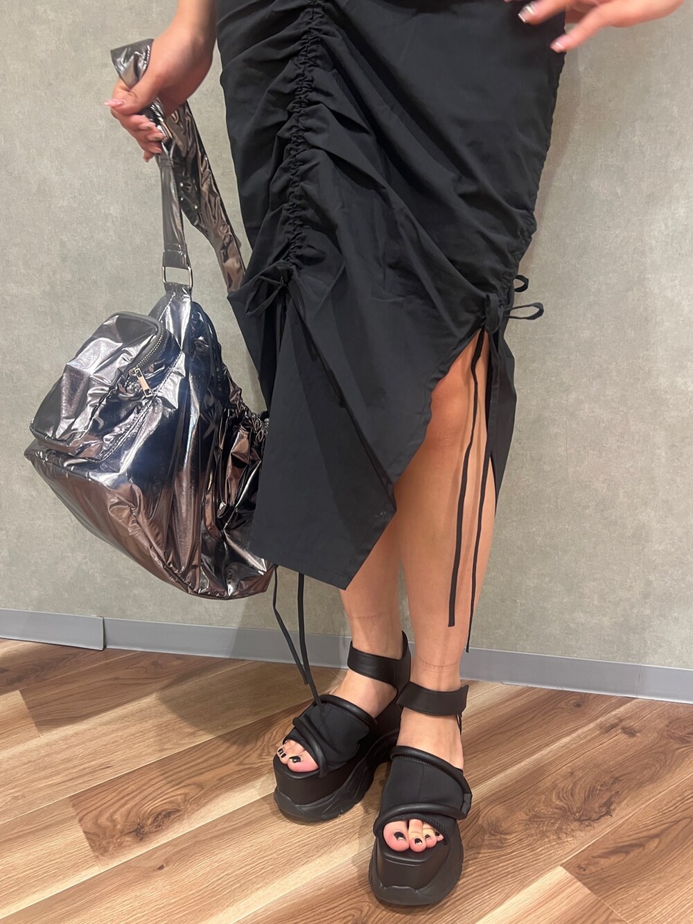 ブラック系のワンピース、シルバー系のハンドバッグ、ブラック系のサンダルを着用したレディースの夏コーディネートの7枚目の写真