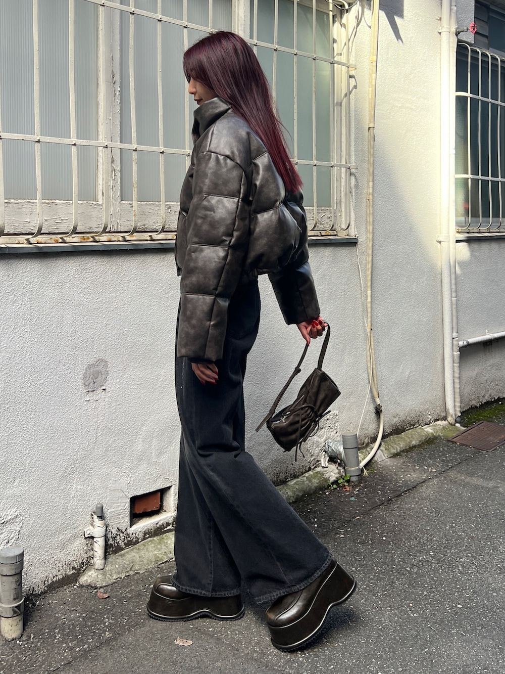 ブラウン系のダウンジャケット/コート、ブラック系のニット/セーター、ブラック系のデニムパンツを着用したレディースの秋コーディネートの2枚目の写真