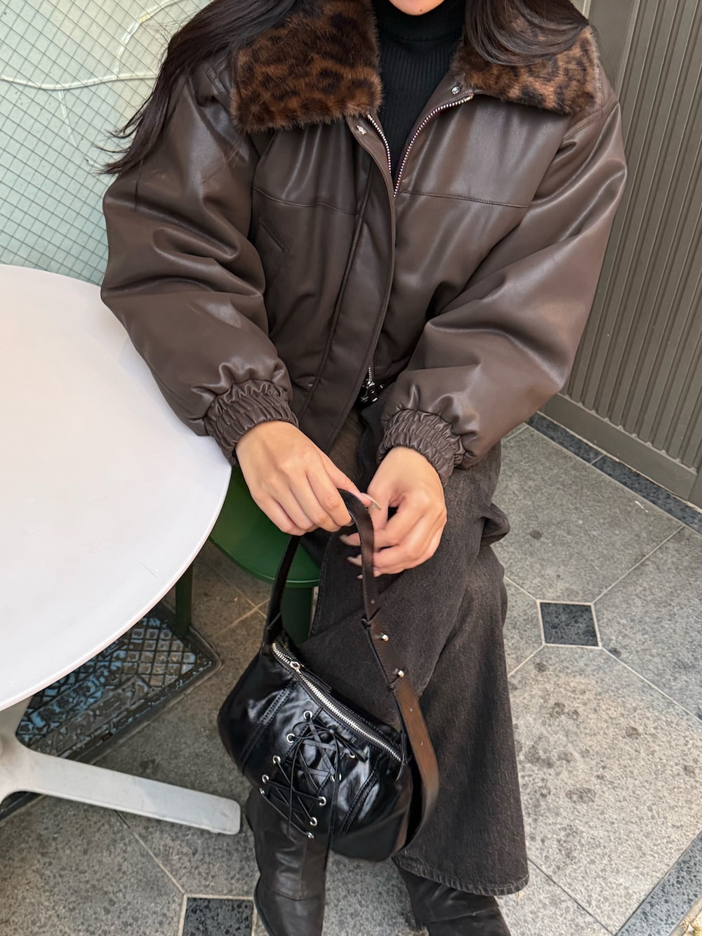 ブラウン系のブルゾン、ブラック系のニット/セーター、ブラック系のデニムパンツを着用したレディースの秋コーディネートの3枚目の写真