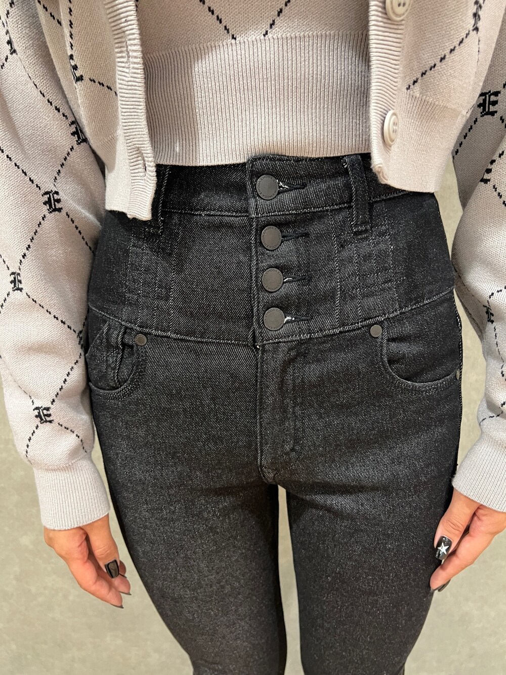 ブラック系のデニムパンツ、ブラック系のブーツ、グレー系のニット/セーターを着用したレディースの秋コーディネートの5枚目の写真