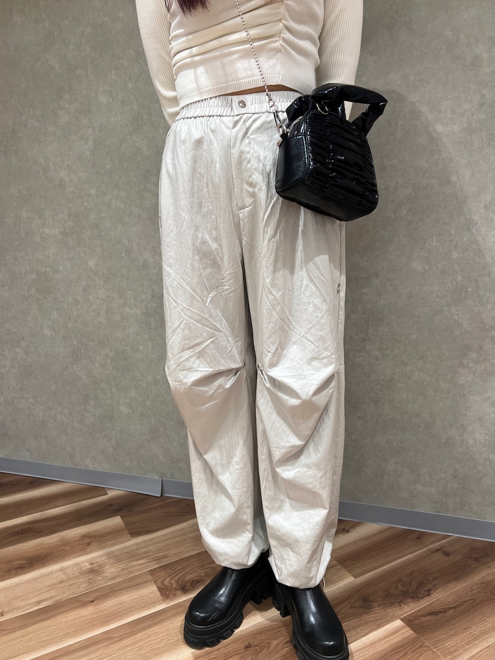 ホワイト系のニット/セーター、ホワイト系のその他パンツ、ブラック系のハンドバッグを着用したレディースの冬コーディネートの6枚目の写真