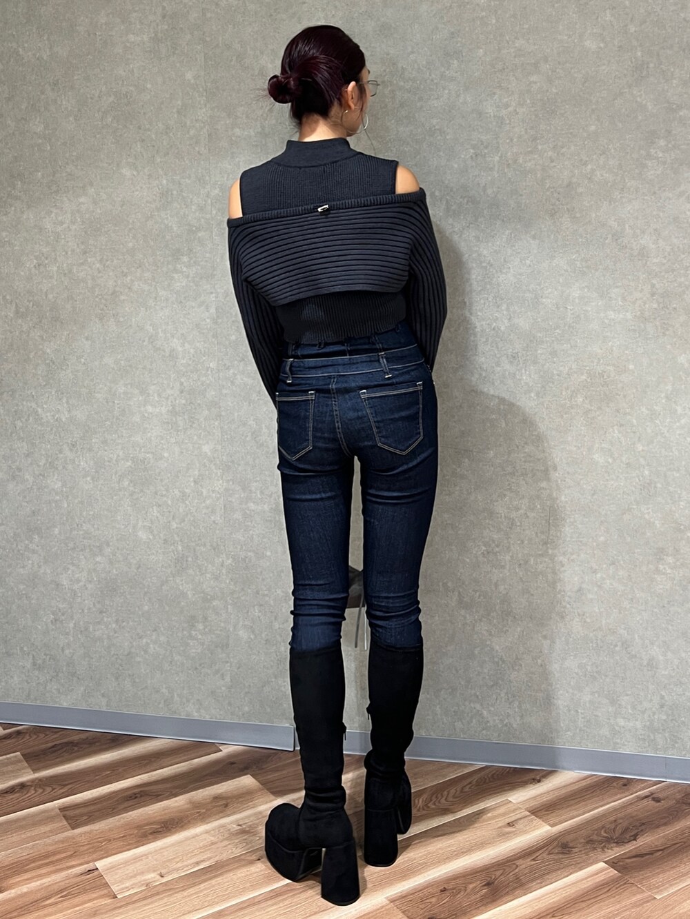 ブラック系のニット/セーター、ブルー系のデニムパンツ、その他のブーツを着用したレディースの秋コーディネートの3枚目の写真