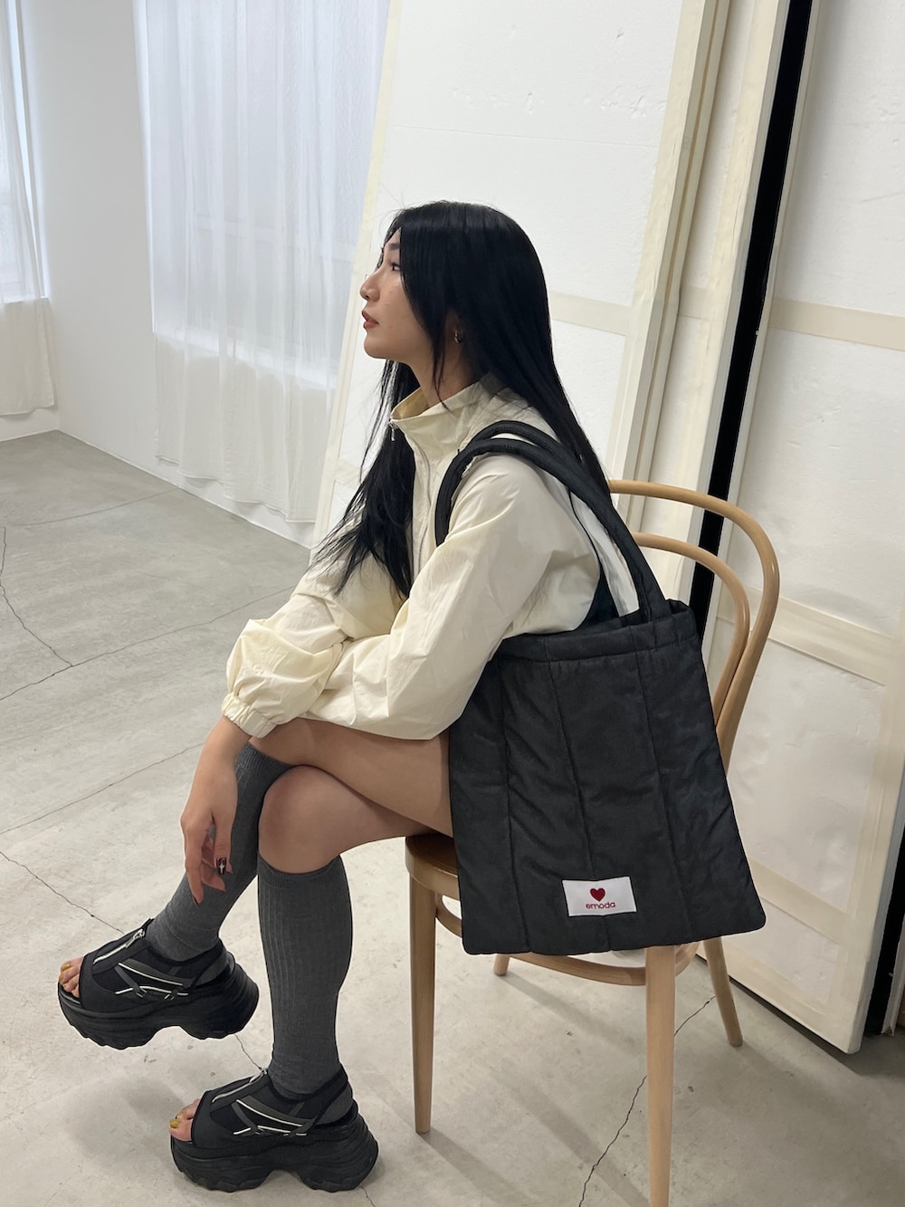 ホワイト系のブルゾン、ホワイト系のスカート、ブラック系のサンダルを着用したレディースの冬コーディネートの4枚目の写真