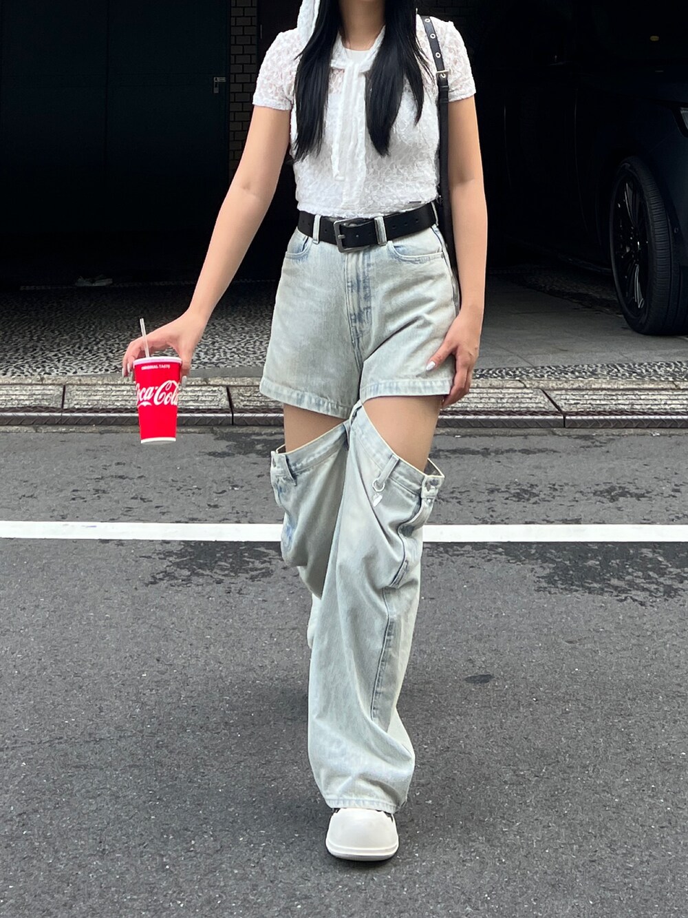 ホワイト系のTシャツ/カットソー、ブルー系のデニムパンツ、ブラック系のハンドバッグを着用したレディースの夏コーディネートの2枚目の写真