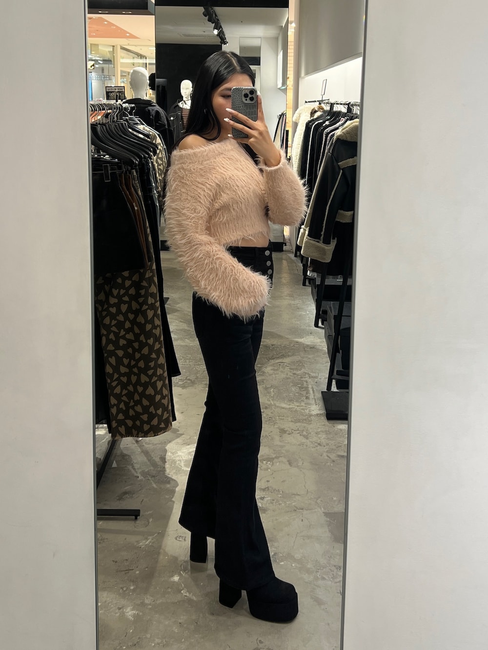 ピンク系のニット/セーター、ブラック系のデニムパンツ、ブラック系のブーツを着用したレディースの冬コーディネートの2枚目の写真