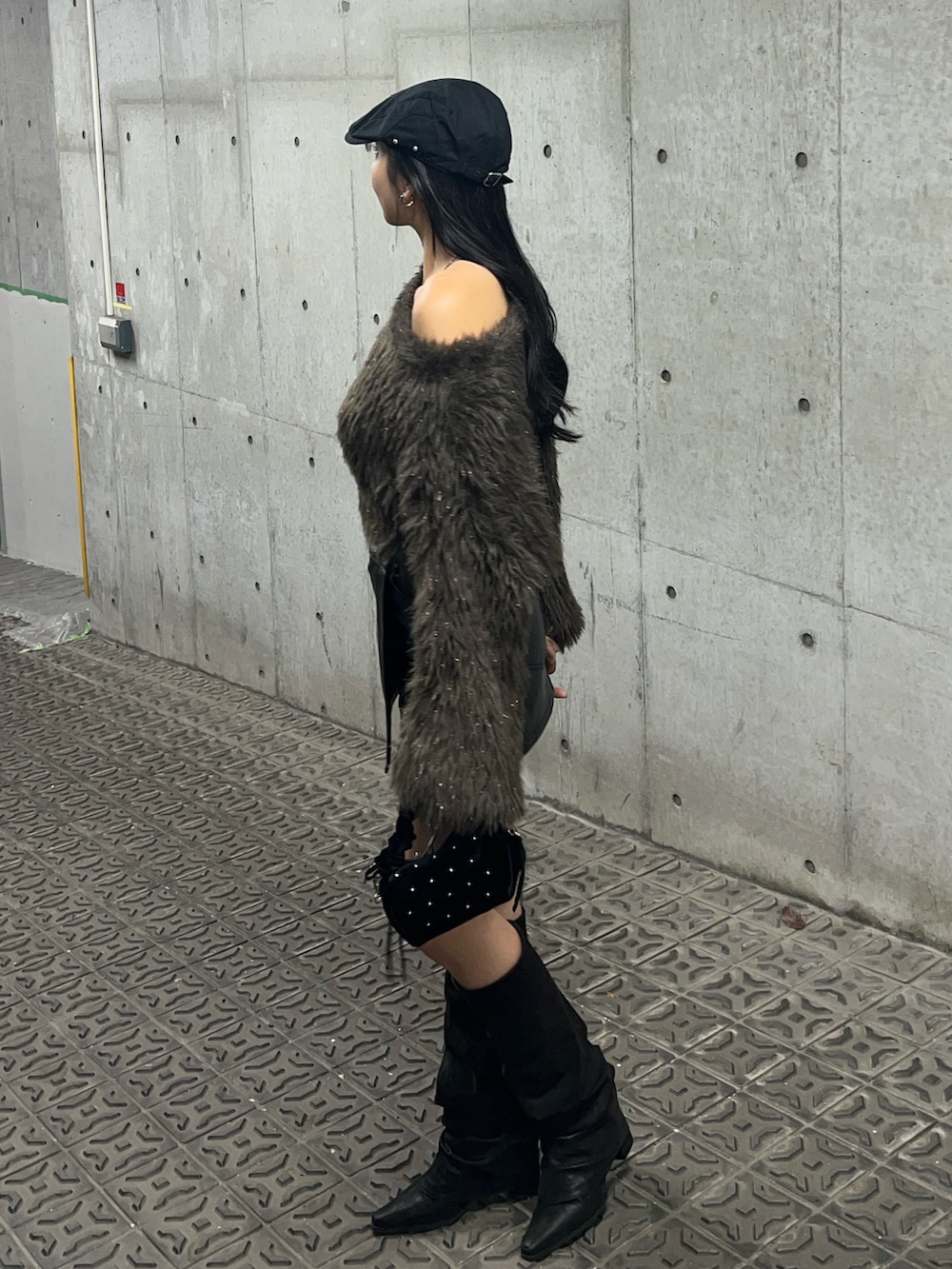 ブラウン系のニット/セーター、ブラック系のスカート、ブラック系のブーツを着用したレディースの秋コーディネートの3枚目の写真