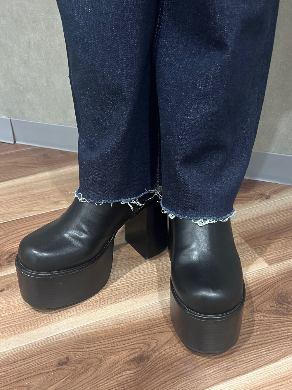 グレー系のニット/セーター、ブルー系のデニムパンツ、ブラック系のハンドバッグを着用したレディースの秋コーディネートの7枚目の写真