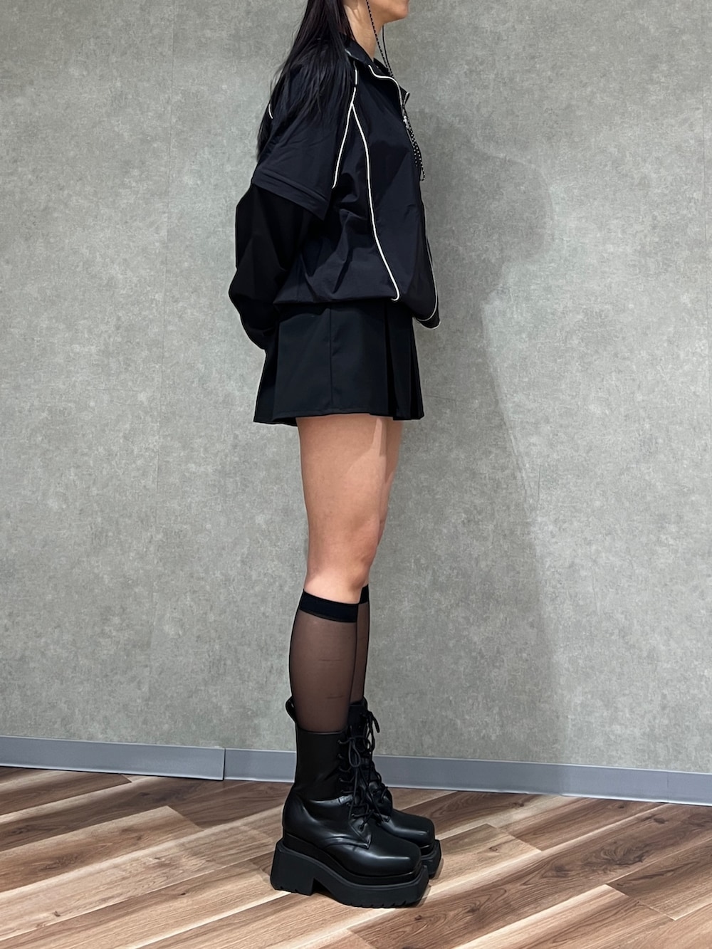 ブラック系のブルゾン、ブラック系のスカート、ブラック系のブーツを着用したレディースの春コーディネートの3枚目の写真