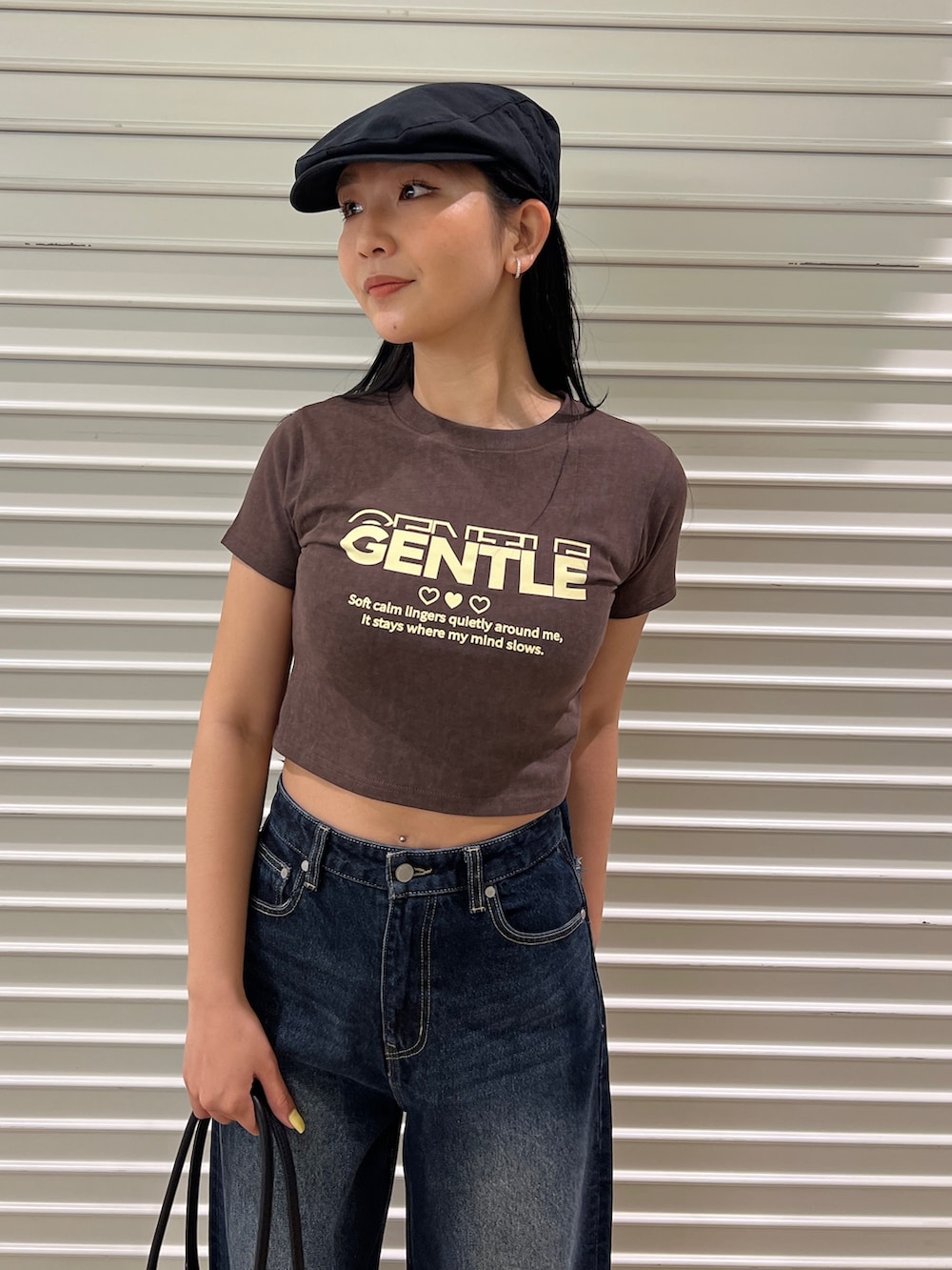 ブラウン系のTシャツ/カットソー、ブルー系のデニムパンツ、ブラック系のサンダルを着用したレディースの春コーディネートの2枚目の写真