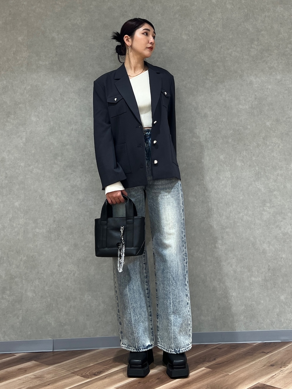 グレー系のテーラードジャケット、ブルー系のデニムパンツ、ブラック系のブーツを着用したレディースの冬コーディネートの3枚目の写真