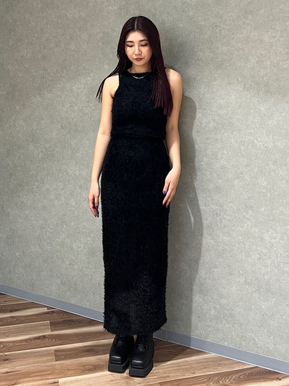 ブラック系のタンクトップ、ブラック系のスカート、ブラック系のブーツを着用したレディースの春コーディネートの2枚目の写真