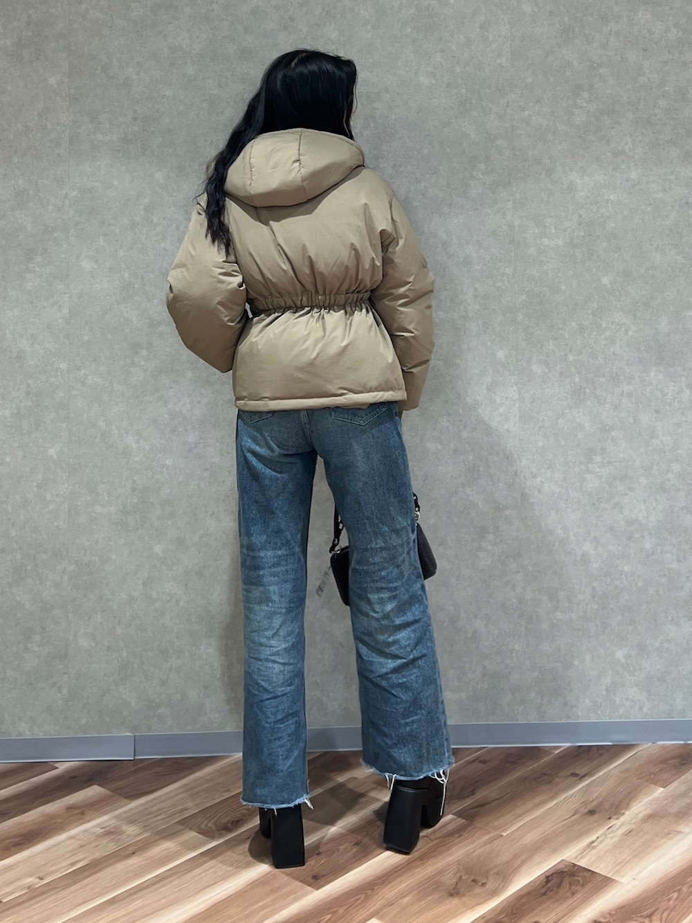 グリーン系のブルゾン、ブルー系のデニムパンツ、ブラック系のブーツを着用したレディースの秋コーディネートの3枚目の写真