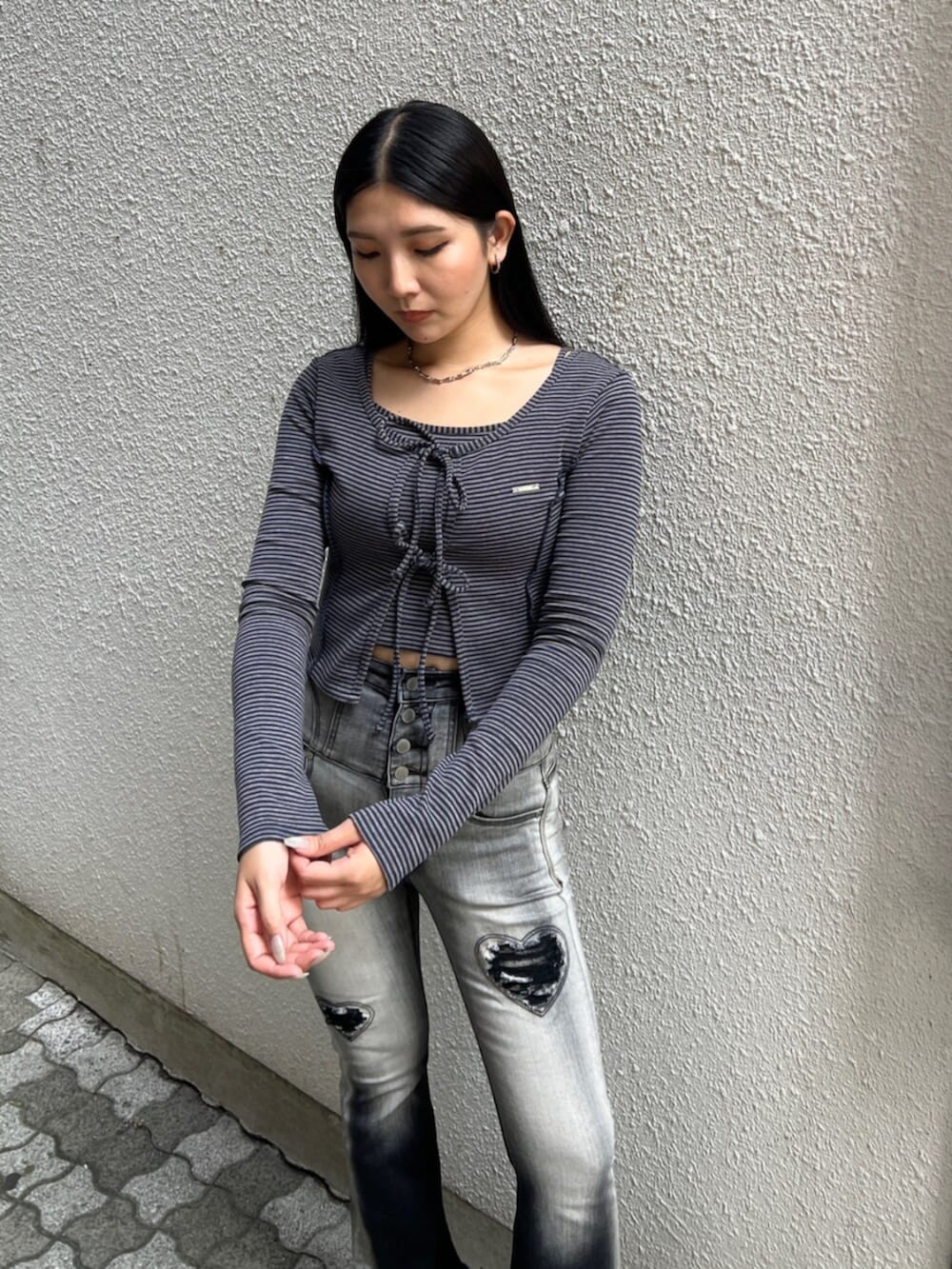 ブラック系のデニムパンツ、ブルー系のTシャツ/カットソー、ブラック系のハンドバッグを着用したレディースの夏コーディネートの5枚目の写真