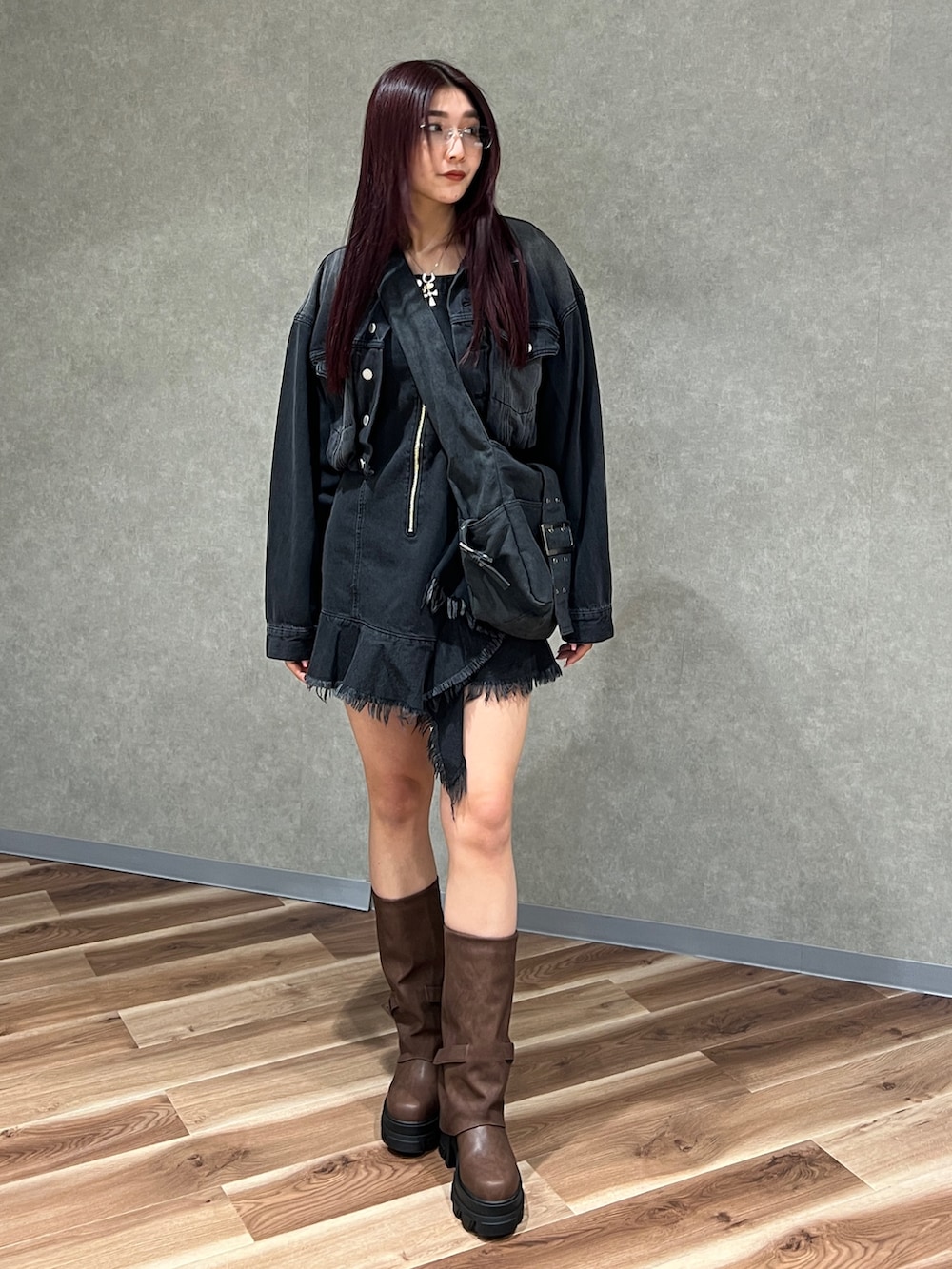 ブラック系のワンピース、ブラック系のデニムジャケット、ブラウン系のブーツを着用したレディースの冬コーディネートの2枚目の写真