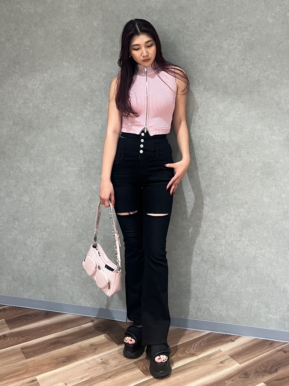 ピンク系のニット/セーター、ブラック系のデニムパンツ、ブラック系のサンダルを着用したレディースの春コーディネートの2枚目の写真