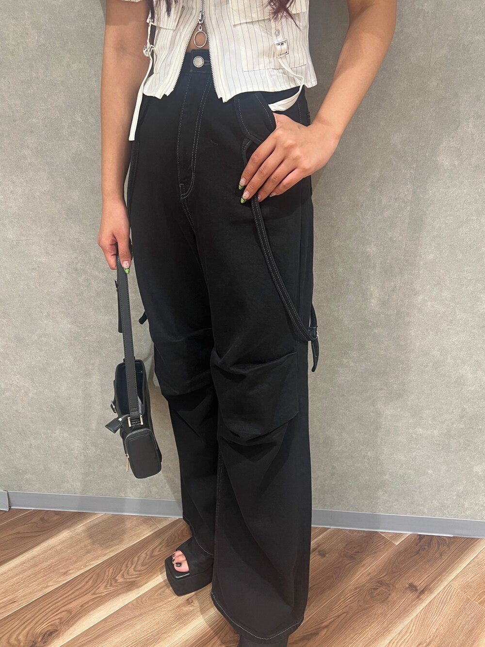 グリーン系のTシャツ/カットソー、ブラック系のデニムパンツ、ブラック系のサンダルを着用したレディースの夏コーディネートの6枚目の写真