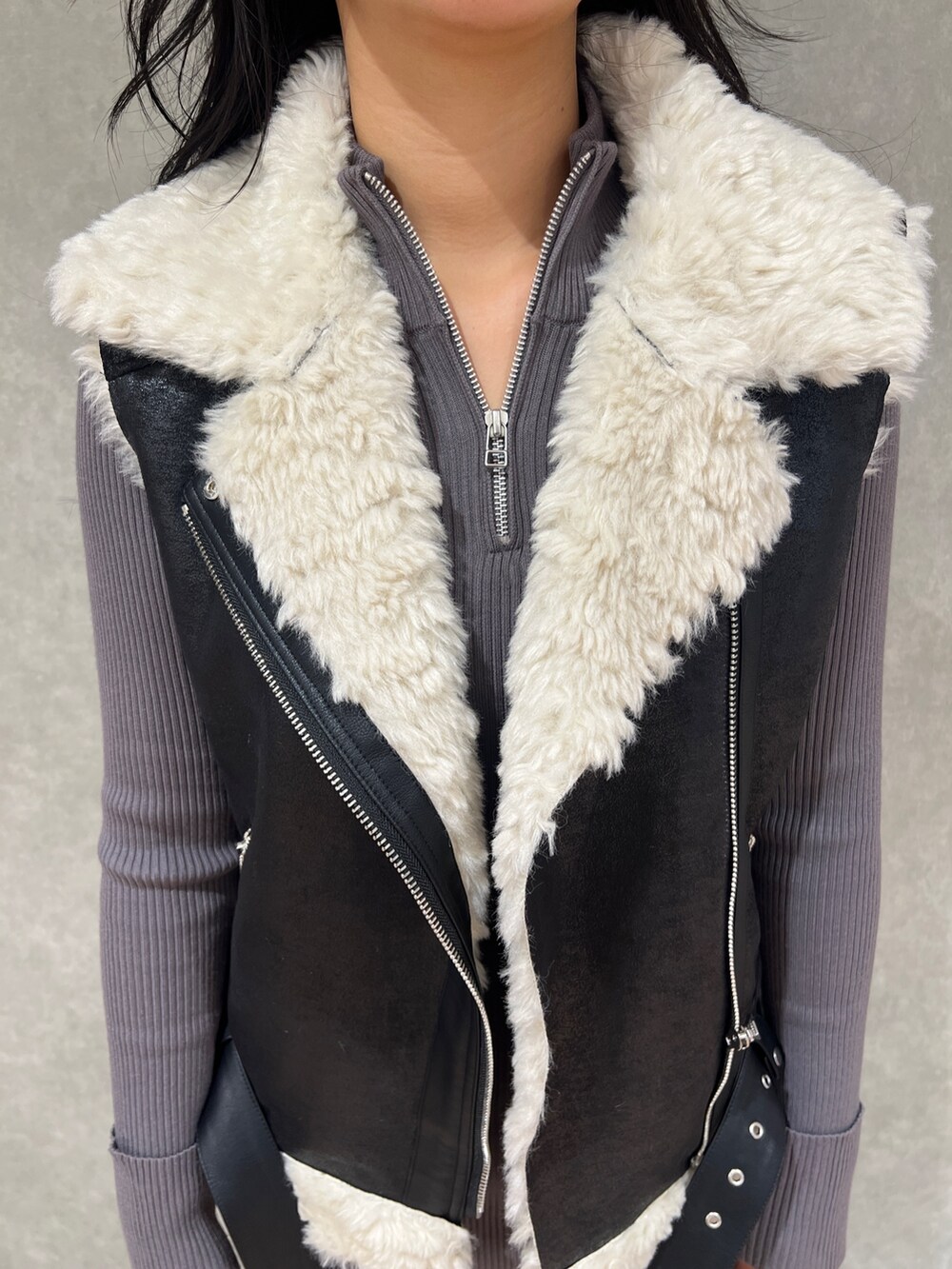 ブラック系のムートンコート、ブラック系のブーツ、グレー系のワンピースを着用したレディースの秋コーディネートの4枚目の写真