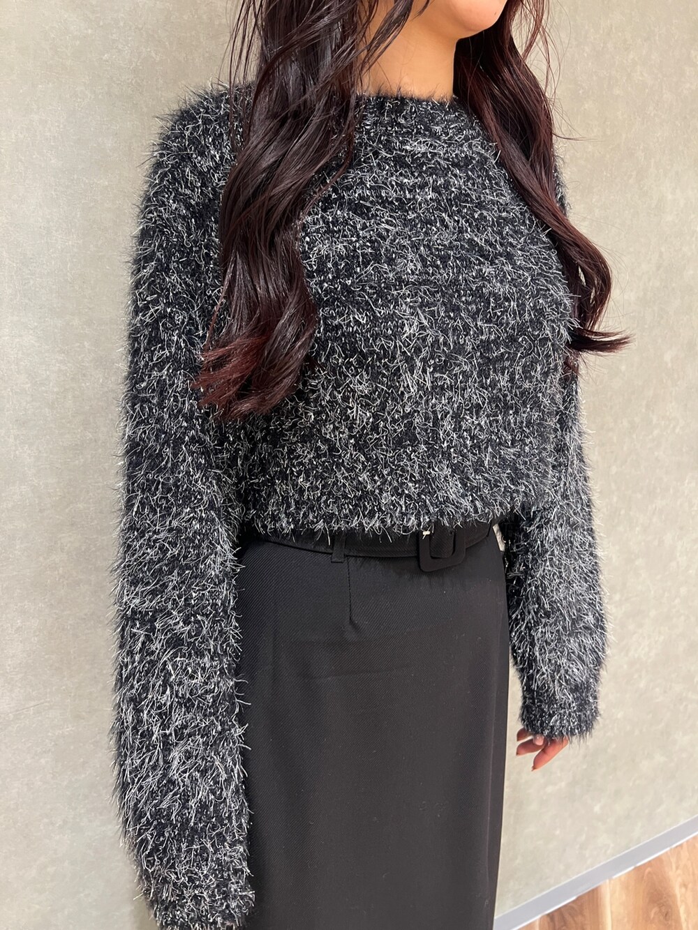 ブラック系のニット/セーター、ブラック系のスカート、ブラック系のブーツを着用したレディースの冬コーディネートの4枚目の写真