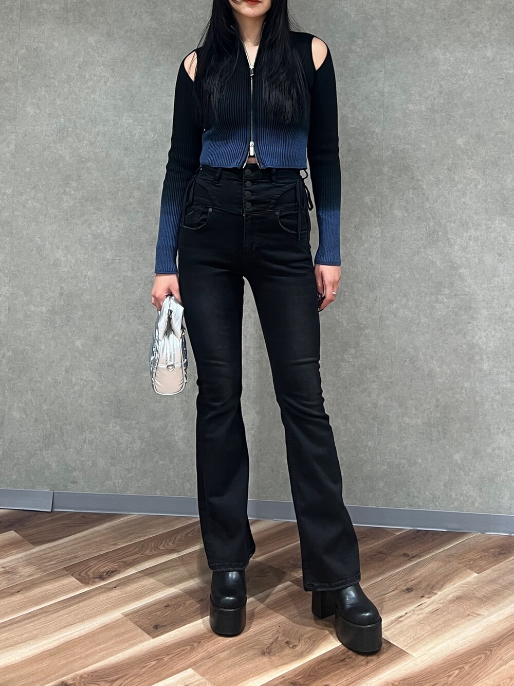 ブラック系のニット/セーター、ブラック系のデニムパンツ、ブラック系のブーツを着用したレディースの春コーディネートの4枚目の写真