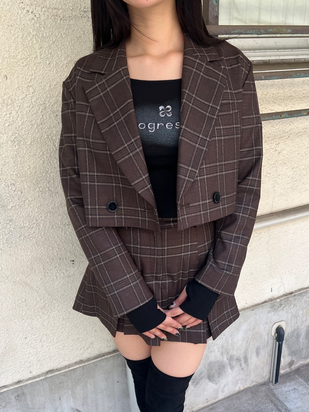 ブラウン系のテーラードジャケット、ブラウン系のスカート、ブラック系のブーツを着用したレディースの夏コーディネートの4枚目の写真