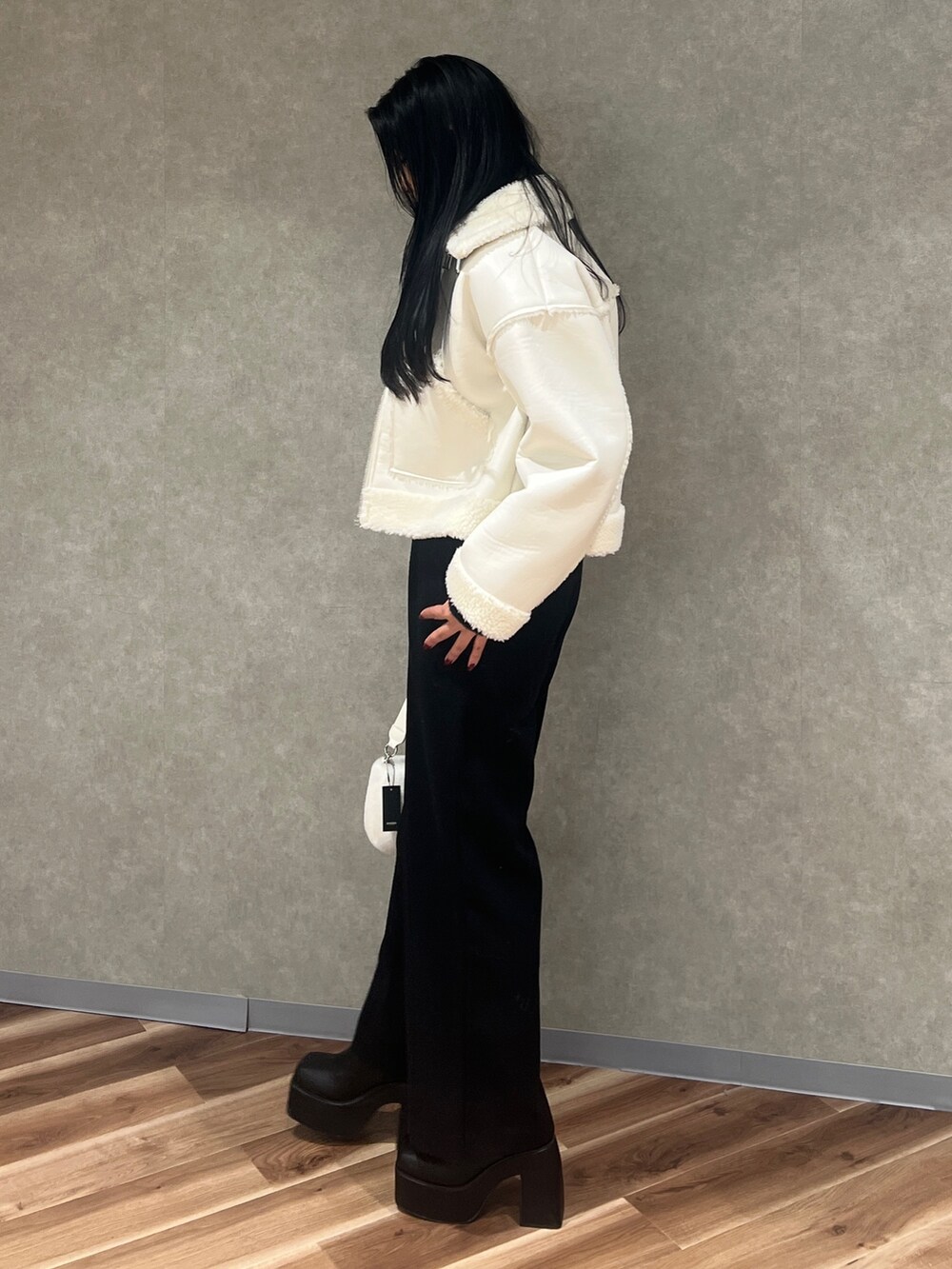 ホワイト系のブルゾン、ブラック系のその他パンツ、ブラック系のブーツを着用したレディースの冬コーディネートの2枚目の写真
