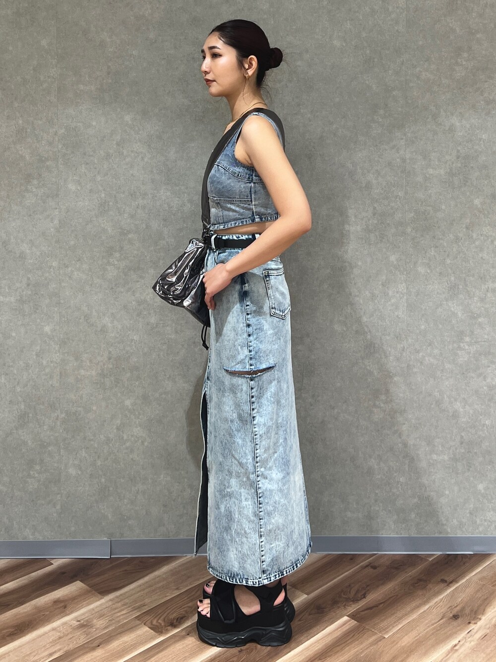 ブルー系のキャミソール、ブルー系のデニムスカート、シルバー系のハンドバッグを着用したレディースの夏コーディネートの3枚目の写真