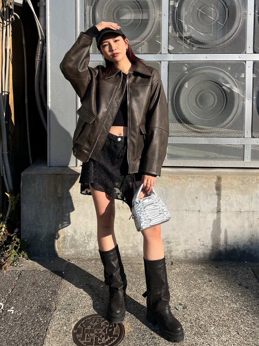 ブラウン系のブルゾン、ブラック系のニット/セーター、ブラック系のスカートを着用したレディースの冬コーディネートの2枚目の写真