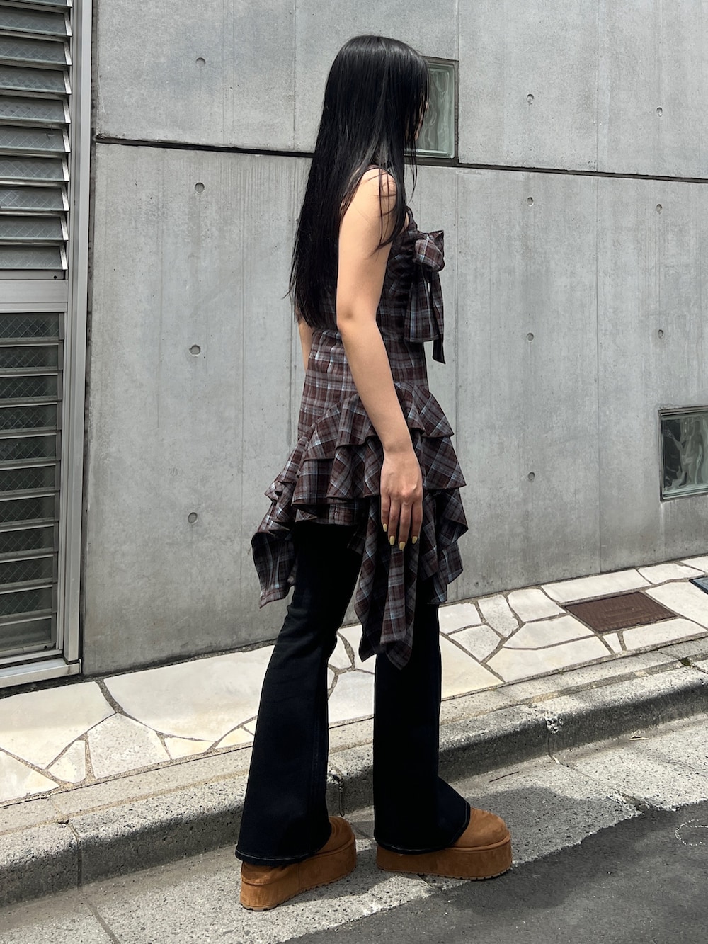 ブラウン系のワンピース、ブラック系のデニムパンツ、イエロー系のその他シューズを着用したレディースの夏コーディネートの2枚目の写真