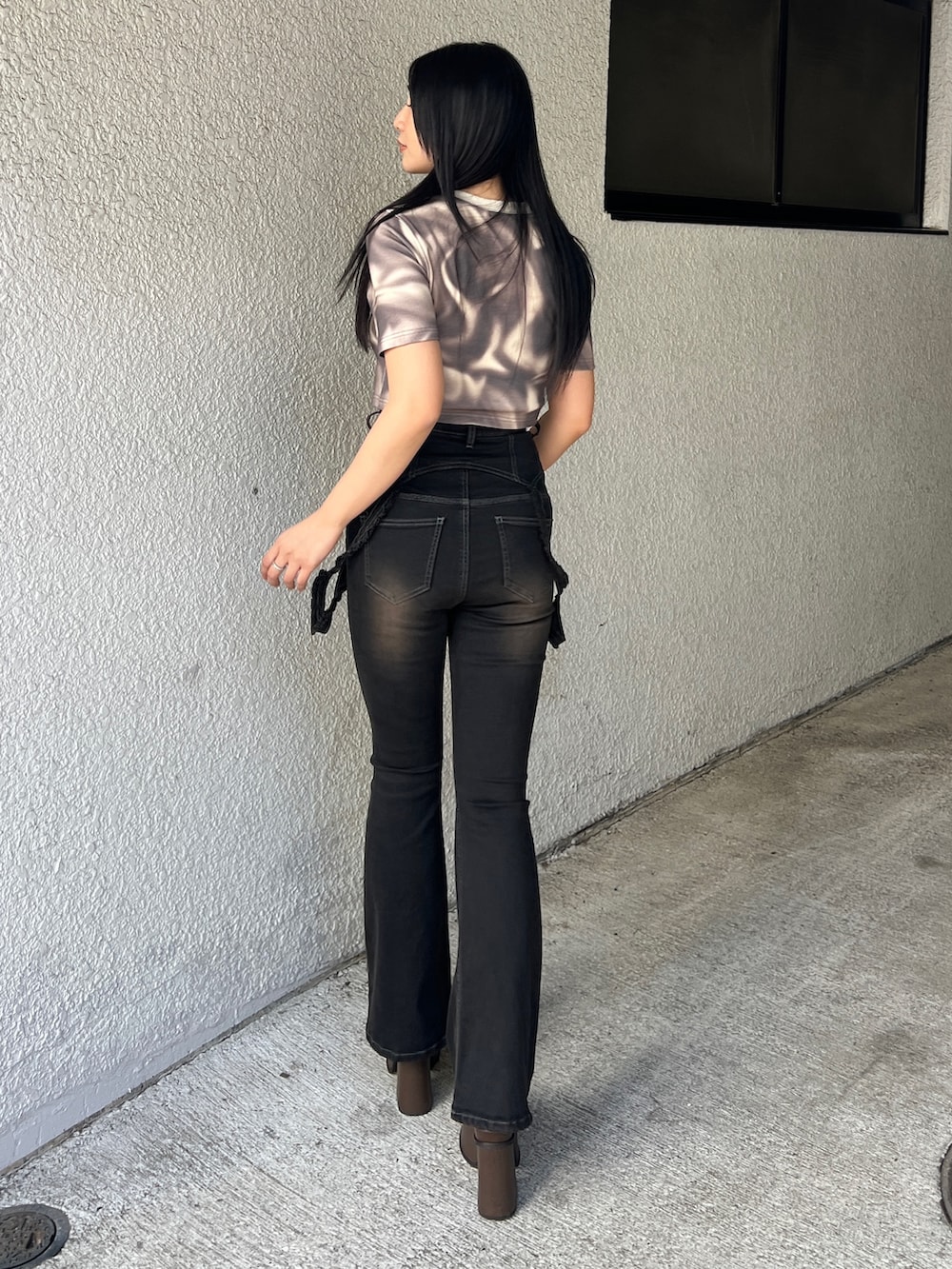 ベージュ系のTシャツ/カットソー、ブラック系のデニムパンツ、ブラウン系のサンダルを着用したレディースの春コーディネートの2枚目の写真