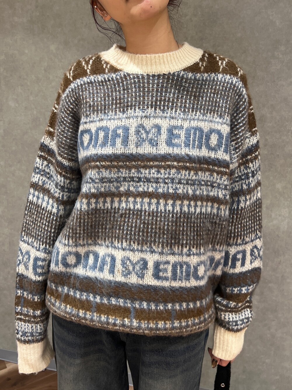 ベージュ系のニット/セーター、ブルー系のデニムパンツ、ブラック系のブーツを着用したレディースの冬コーディネートの4枚目の写真