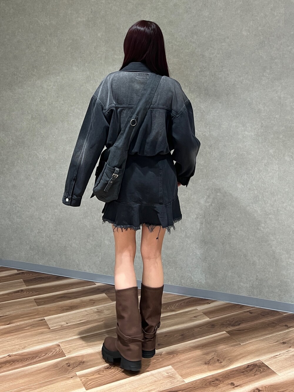 ブラック系のワンピース、ブラック系のデニムジャケット、ブラウン系のブーツを着用したレディースの冬コーディネートの4枚目の写真