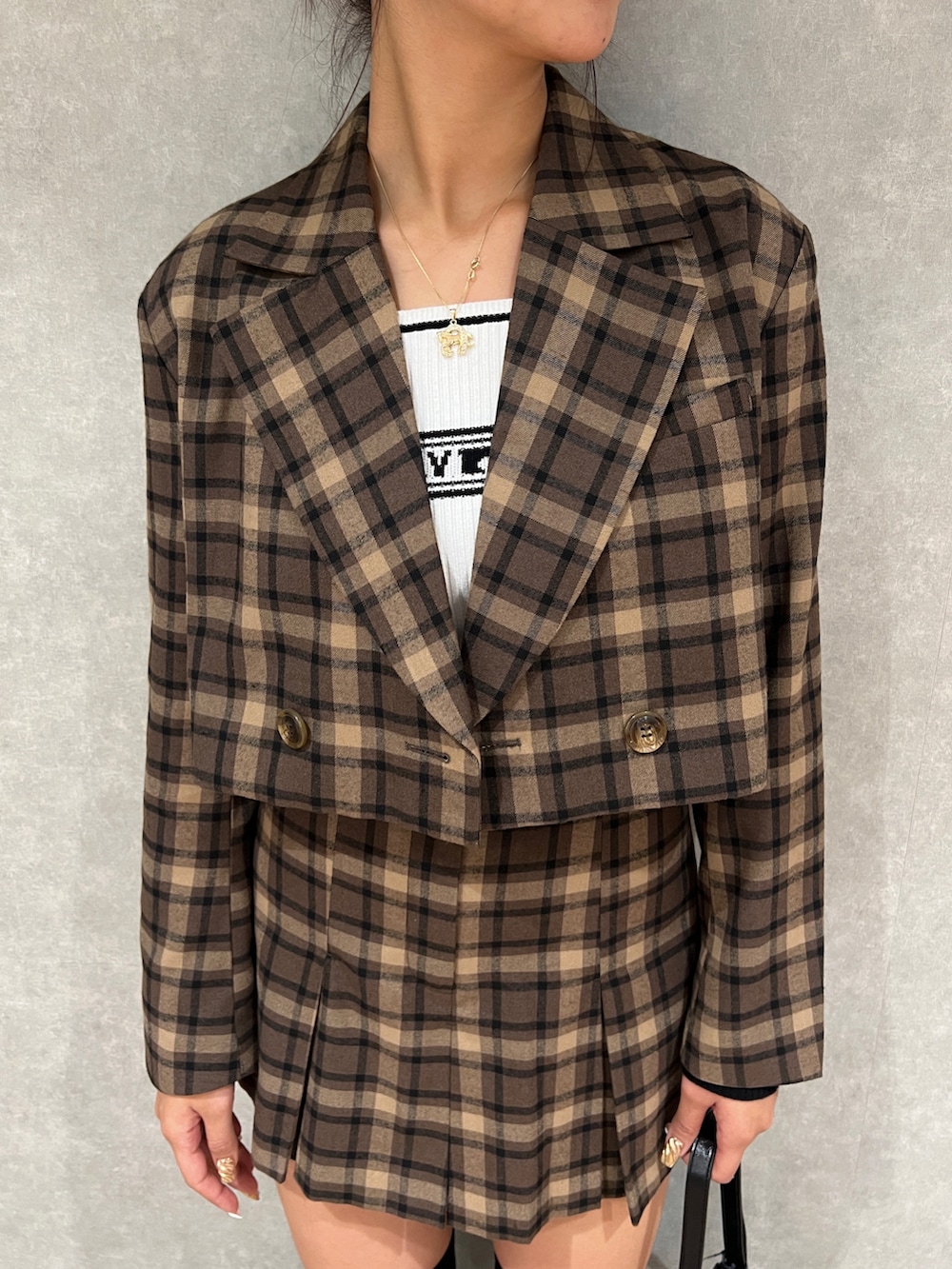 その他のテーラードジャケット、ブラック系のブーツ、ホワイト系のニット/セーターを着用したレディースの秋コーディネートの4枚目の写真