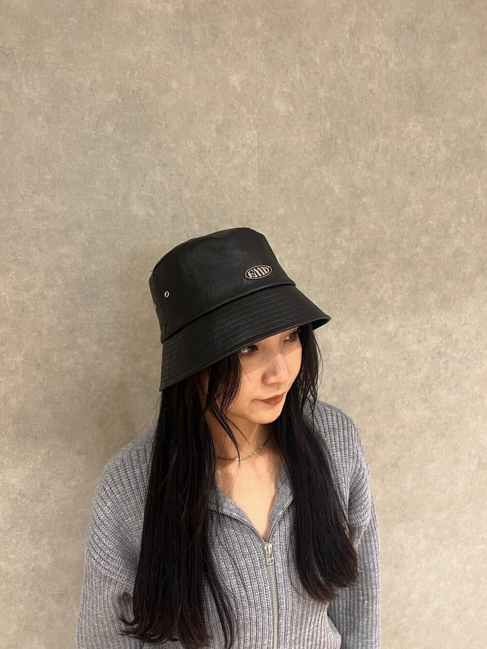 グレー系のスカート、グレー系のニット/セーター、ブラック系のブーツを着用したレディースの冬コーディネートの4枚目の写真