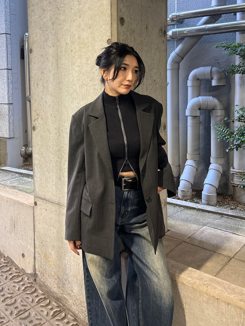 グレー系のテーラードジャケット、ブラック系のニット/セーター、ブルー系のデニムパンツを着用したレディースの冬コーディネートの3枚目の写真