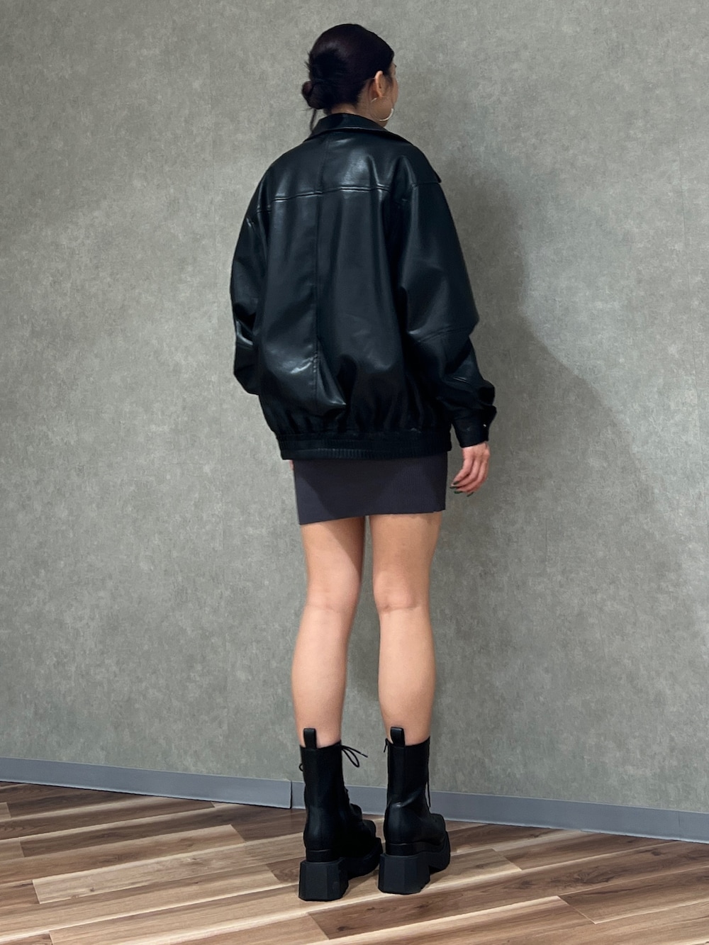 グレー系のワンピース、ブラック系のブルゾン、ブラック系のブーツを着用したレディースの冬コーディネートの3枚目の写真