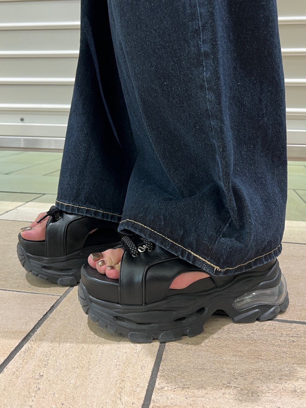 ブラウン系のTシャツ/カットソー、ブルー系のデニムパンツ、ブラック系のサンダルを着用したレディースの春コーディネートの5枚目の写真