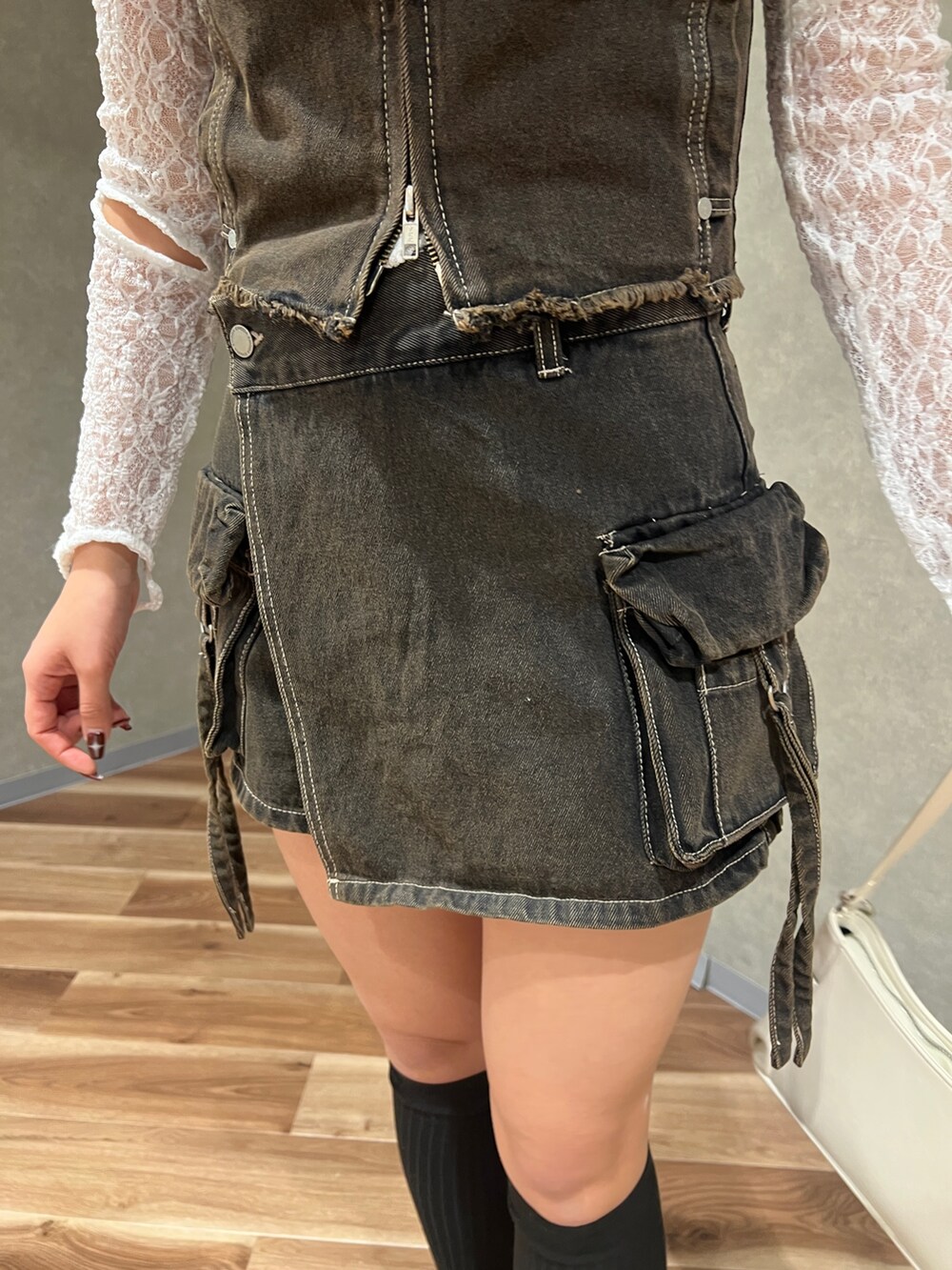 ブラック系のベスト、ブラック系のその他パンツ、ホワイト系のハンドバッグを着用したレディースの春コーディネートの6枚目の写真