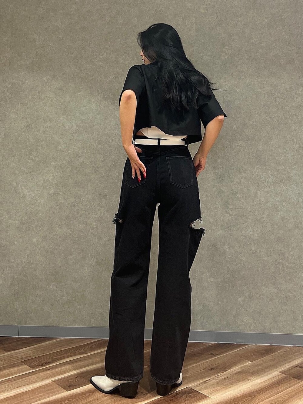 ブルー系のデニムパンツ、ホワイト系のニット/セーター、ホワイト系のブーツを着用したレディースの夏コーディネートの3枚目の写真