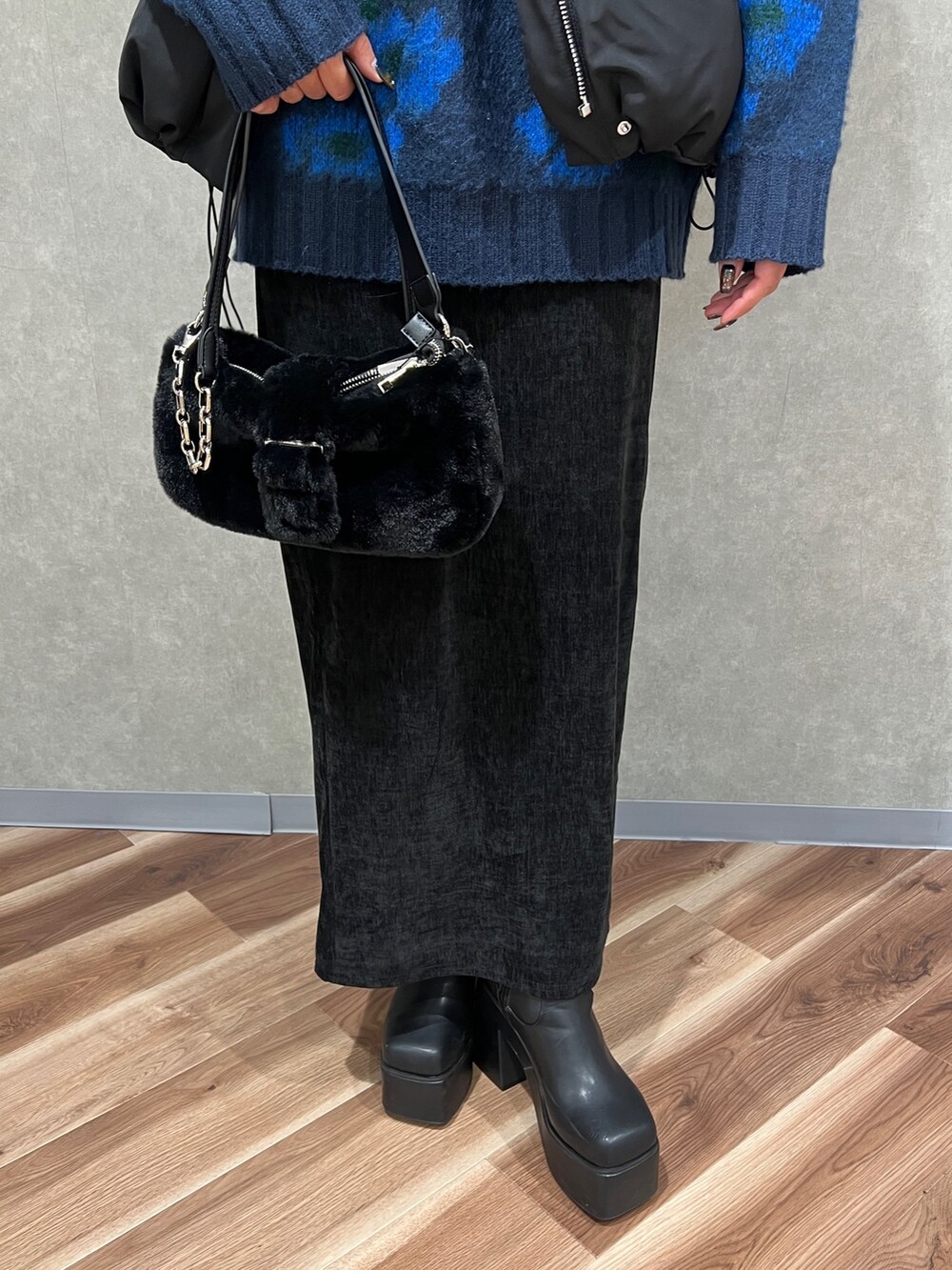 ブルー系のニット/セーター、ブラック系のブルゾン、ブラック系のスカートを着用したレディースの秋コーディネートの6枚目の写真