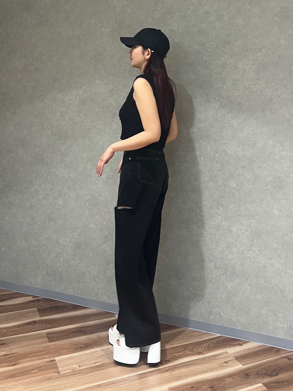 ブラック系のタンクトップ、ブラック系のデニムパンツ、ホワイト系のサンダルを着用したレディースの夏コーディネートの3枚目の写真