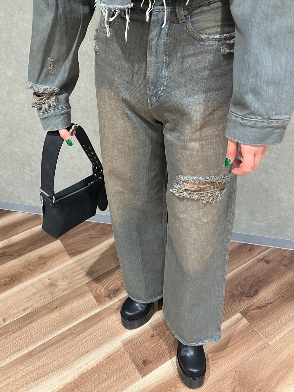 グレー系のデニムジャケット、グレー系のデニムパンツ、ブラック系のブーツを着用したレディースの冬コーディネートの5枚目の写真