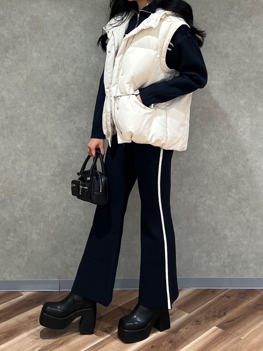 ホワイト系のブルゾン、ブラック系のニット/セーター、ブルー系のその他パンツを着用したレディースの秋コーディネートの3枚目の写真