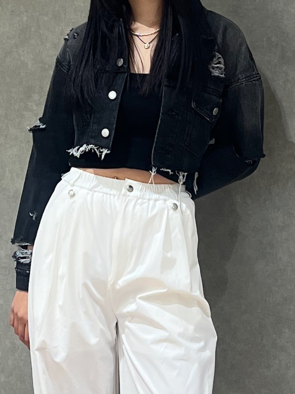 ブラック系のデニムジャケット、ブラック系のキャミソール、ホワイト系のその他パンツを着用したレディースの春コーディネートの2枚目の写真